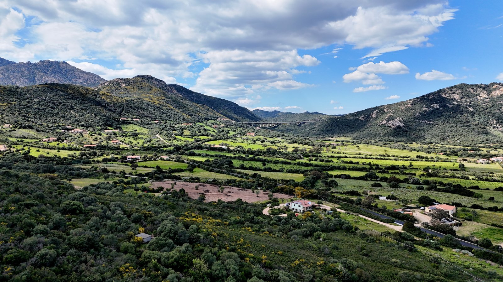 Der Weitblick ins Tal bietet grüne Weiten und Berge im Hintergrund Der Weitblick ins Tal bietet grüne Weiten und Berge im Hintergrund